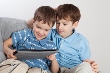 Two brothers playing on tablet
