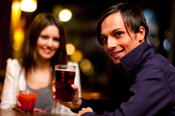 Couple of friends having a drink in a bar