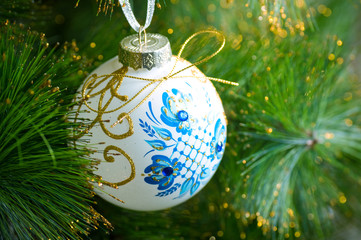 christmas decorations hanging on christmas tree with shiny glare