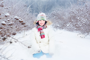 Fototapeta na wymiar Happy smiling child playing in a snow field