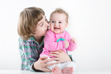 Portrait of two happy kids, cute boy and his baby sister