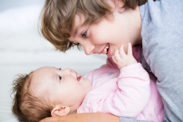 Baby girl laughing to her brother