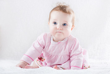 Very funny baby girl in a pink dress