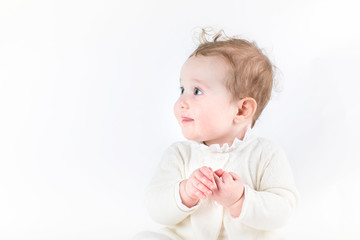 Profile of a cute baby girl in a white knitted cardigan