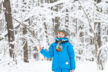Fototapeta na wymiar Boy playing with snow in a winter park
