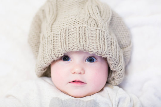 Little baby in a huge knitted hat