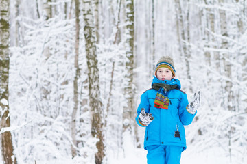Fototapeta na wymiar Cute boy playing in a winter forest