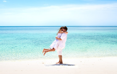 Beautiful young couple hugging on a stunning tropical beach