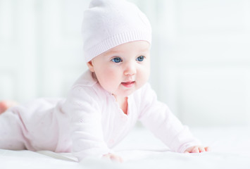 Happy smiling baby girl in a pink knitted hat