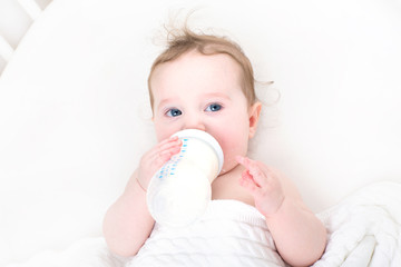 Little baby drinking milk from a bottle