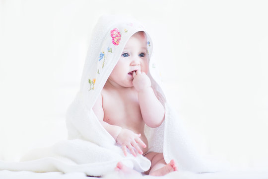 Sweet baby girl in a cross-stitched handmade towel