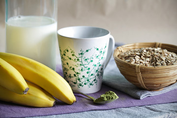 Matcha smoothie ingredients of milk, oats and bananas