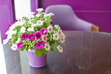 Beautiful plastic flowers in metal vase with copy space.