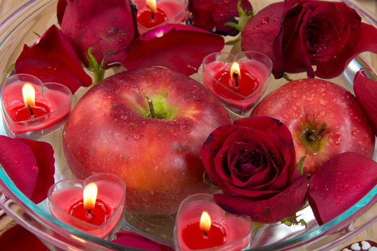 Valentine candles, apple, coffee cup and rose petals