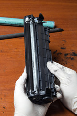 hands repairing laser toner cartridge