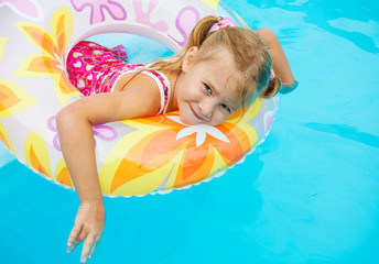 Fototapeta na wymiar little girl in the pool with rubber ring