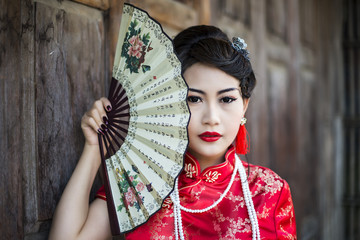 Chinese girl in traditional Chinese cheongsam blessing