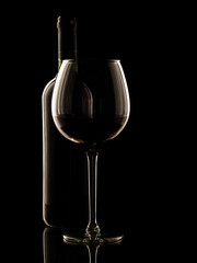 Red wine bottle and glass on black background