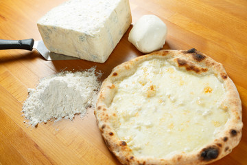Typical Italian Pizza with ingredients in the background on a wo