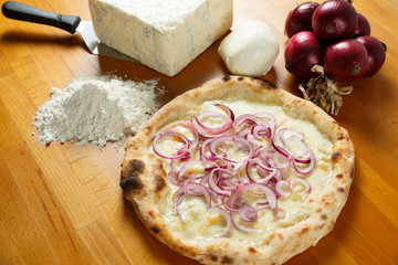 Italian Pizza, ingredients in the background on a wood table