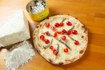 Typical Italian Pizza, ingredients in background on wood table