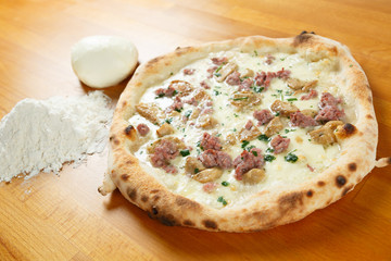 Italian Pizza, ingredients in the background on a wood table