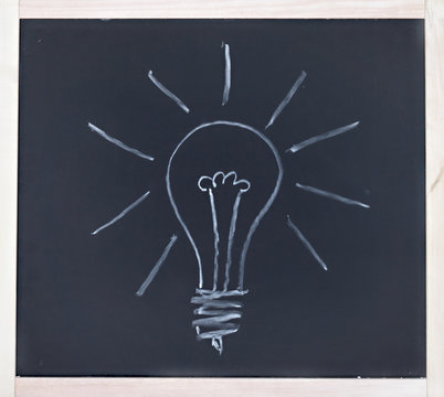Light bulb drawn in chalk on blackboard