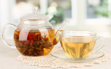 Exotic green tea with flowers in glass teapot