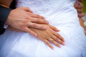 Obraz na płótnie Canvas wedding rings on hands of newlyweds