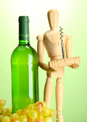 Mannequin with corkscrew and wine bottle, on green background