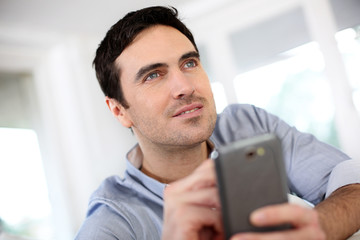 Man at home using smartphone