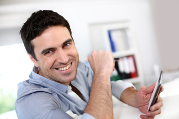 Smiling guy connected on smartphone