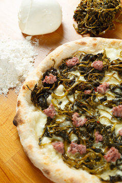 Italian Pizza, ingredients in background on a wood table