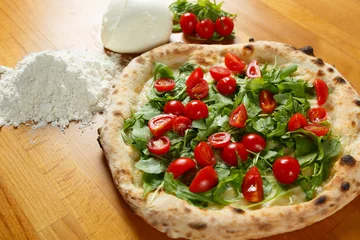Schilderijen op glas Typical Italian Pizza, ingredients in background on wood table © luca.viola(IT)
