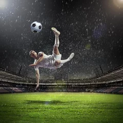 Zelfklevend Fotobehang voetballer die de bal slaat © Sergey Nivens