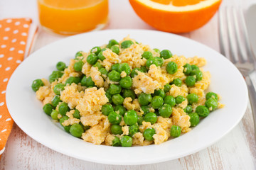 egg with peas on the plate and orange juice