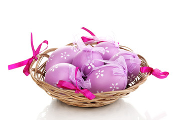 Colorful easter eggs in basket isolated on white