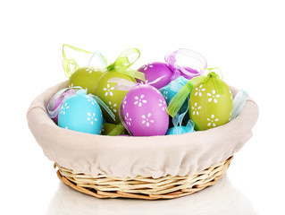 Colorful easter eggs in basket isolated on white