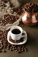 Cup of coffee and pot on wooden background