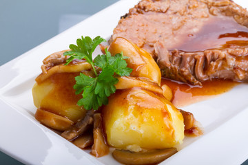 Roast pork with gravy and potatoes on the plate