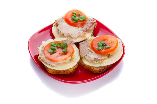 Sandwiches with roast pork, cheese and tomato on the plate