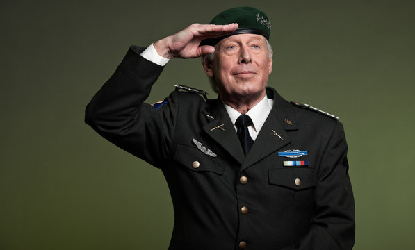 Military general wearing beret. Salutation. Studio portrait.