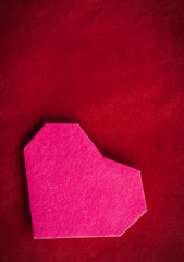 Hand made paper heart on paper as background.