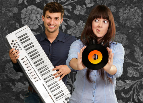 Young Girl Showing Vinyl Against Young Man Holding Piano