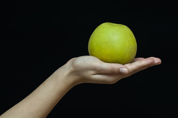 Female hand with a green apple
