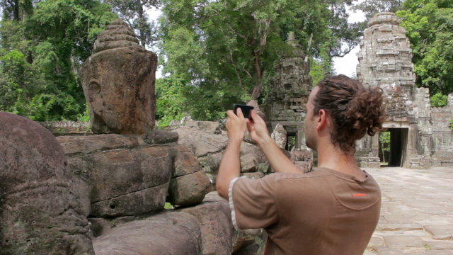 alone visitor takes own picture in preah khan temple, angkor