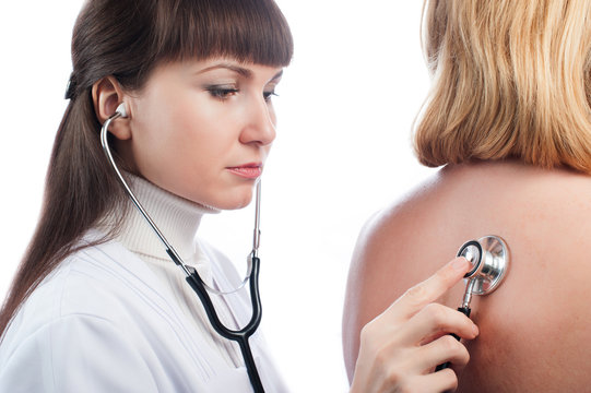 Doctor examining lungs of a female patient with stethoscope