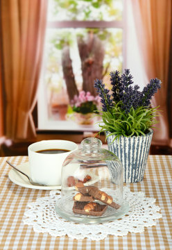 Chocolate pieces under glass cover and hot drink