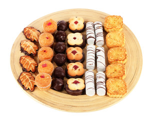 Sweet cookies on wooden plate isolated on white.