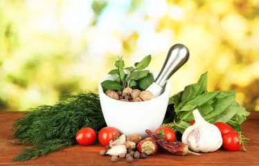 Composition of mortar, spices, tomatoes and  green herbs,